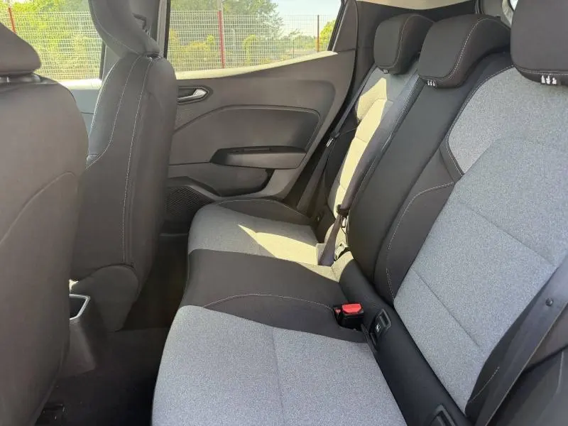 Vue intérieure de la banquette arrière gris clair et noir de la Renault Clio 1.5 dCi 2025, avec ceintures et appuie-têtes visibles.