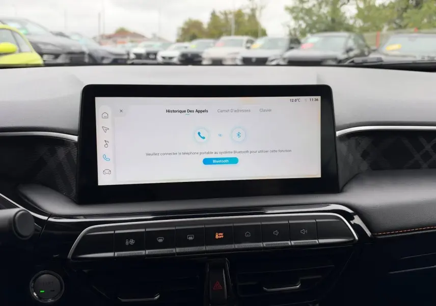 Vue rapprochée de l’écran tactile central et de la console noire avec commandes climatisation dans un MG3 Como Blue 2025.