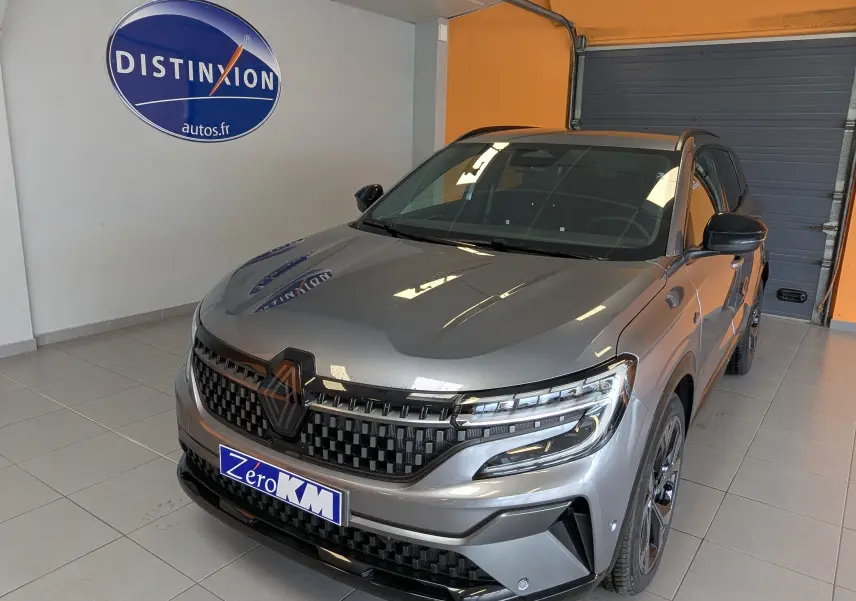 Renault Austral e-tech gris schist en 3/4 avant droit, hayon motorisé et calandre noire distinctive.