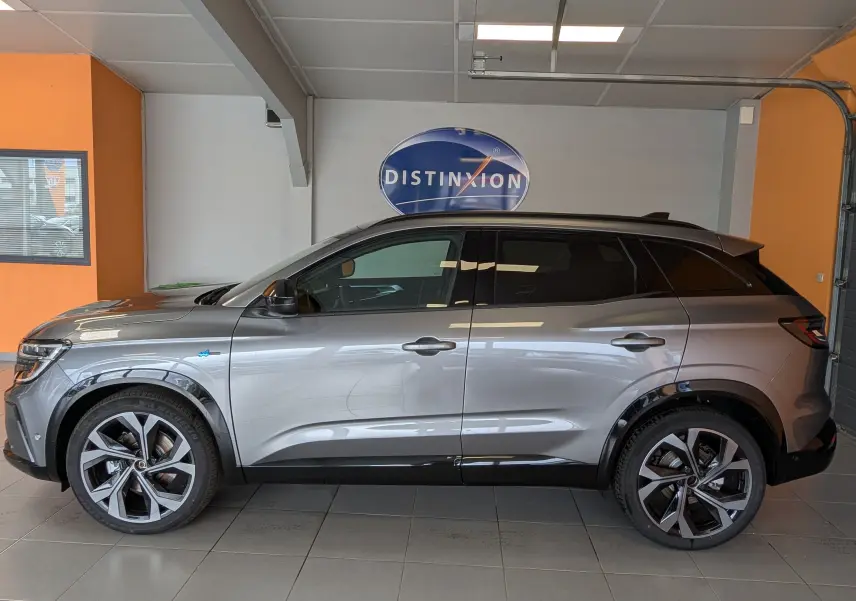 Renault Austral e-tech gris schist vu de profil côté gauche, avec jantes alliage et hayon motorisé visible.