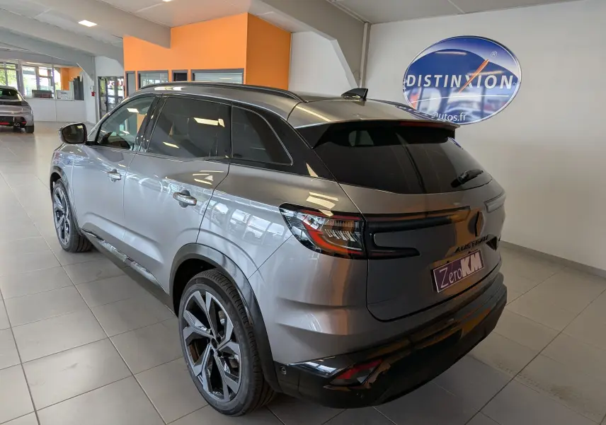 Vue 3/4 arrière droite du Renault Austral gris schist avec hayon motorisé et vitres teintées en showroom.