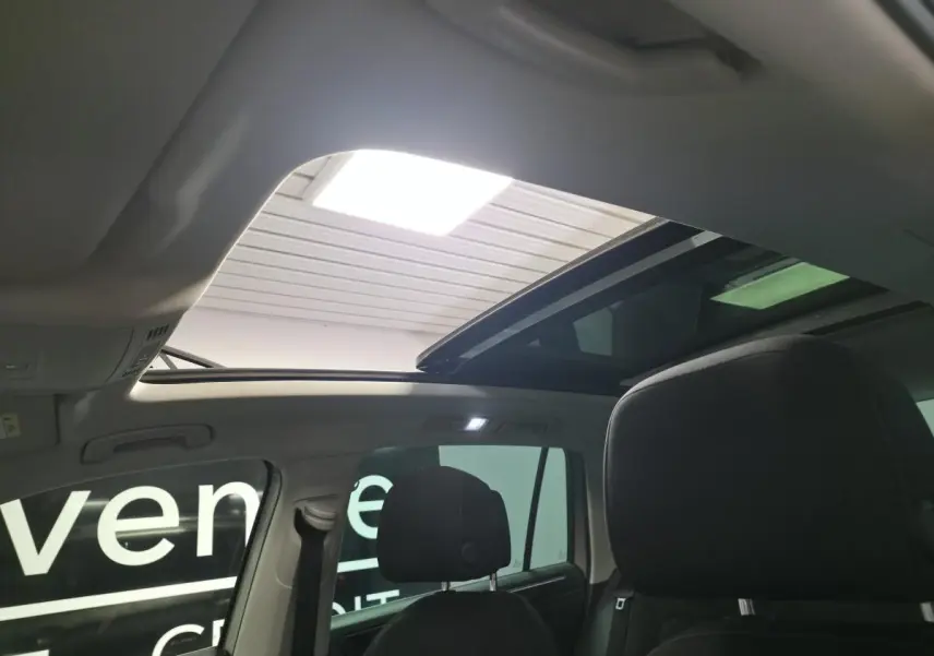 Intérieur du Volkswagen Tiguan 2020, vue arrière des sièges noirs avec toit ouvrant panoramique ouvert.