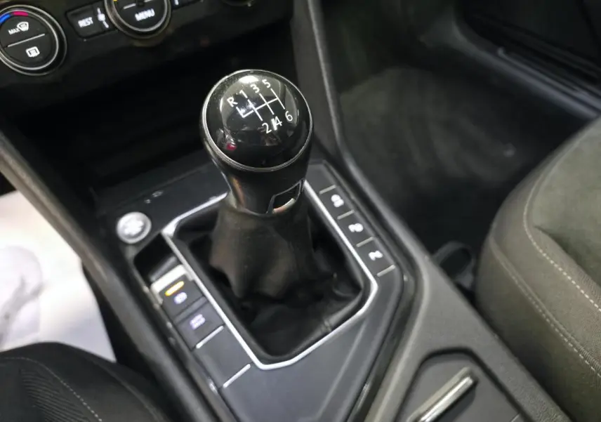 Le levier de vitesses manuel noir du Volkswagen Tiguan 2020 vu de dessus, entouré de commandes sur la console centrale.