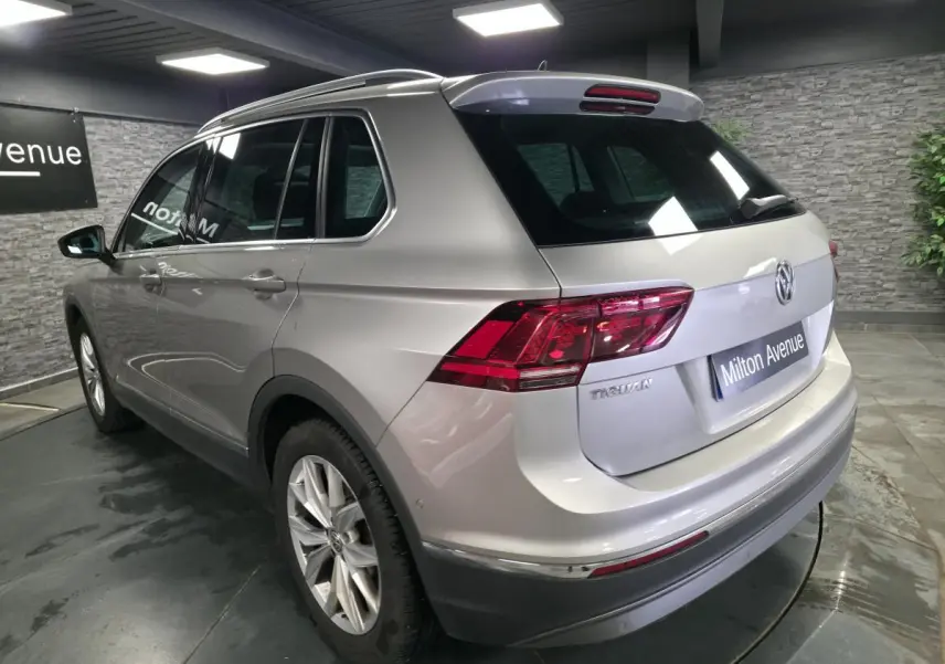 Volkswagen Tiguan gris métallisé vu en 3/4 arrière droit avec feux arrière LED et jantes alliage 18 pouces.