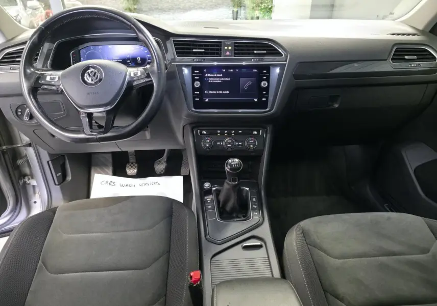 Intérieur avant du Volkswagen Tiguan 2020, vue centrée sur le volant cuir multifonctions et la console avec boîte manuelle.