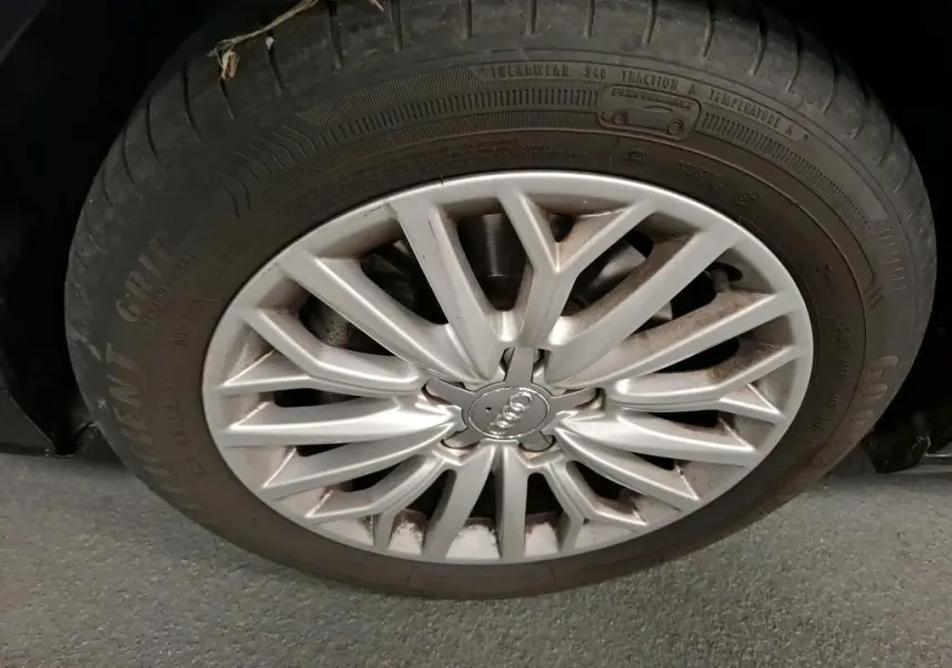 Gros plan sur la jante en aluminium 10 branches de l'Audi A3 Sportback noire, roue avant droite visible.