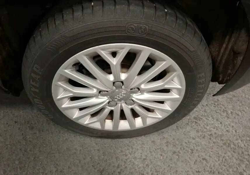 Gros plan sur la jante en aluminium 10 branches argentée d’une Audi A3 Sportback noire, pneu Goodyear visible.