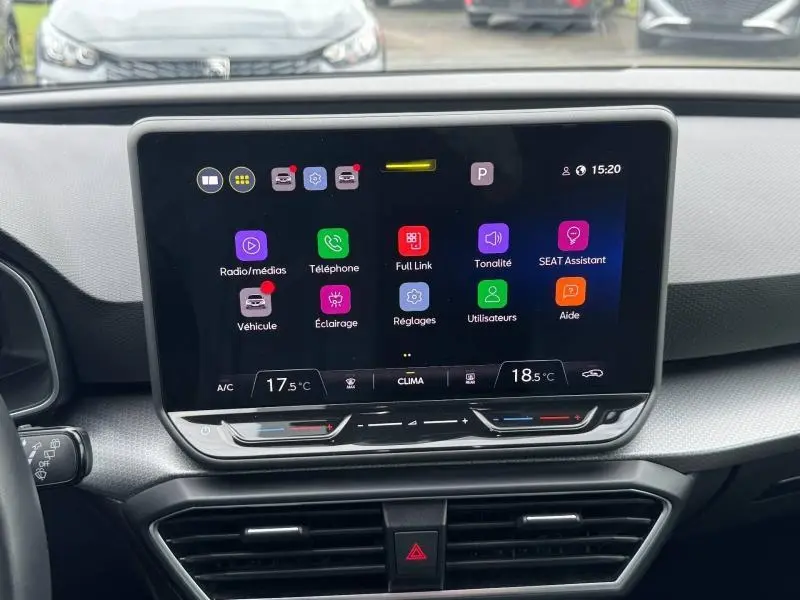 Vue intérieure du tableau de bord de la SEAT LEON 2025 avec écran tactile central affichant les options multimédia et climatisation.