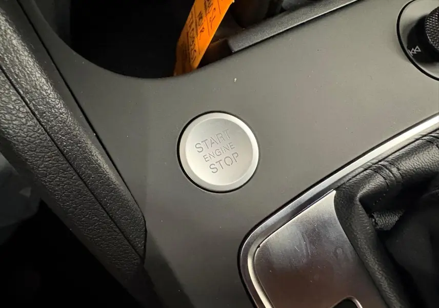 Gros plan sur le bouton start/stop moteur dans l’habitacle d’un Audi Q2 Noir Mythic, version S Line 2026.