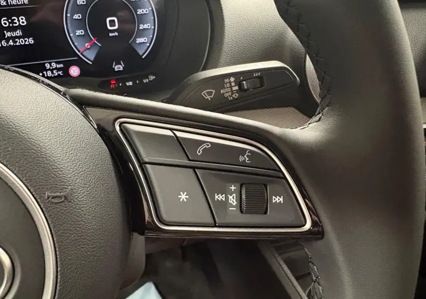 Gros plan sur les commandes multimédia à droite du volant d’un Audi Q2 35 TFSI 150 S tronic 7 S line 2026.