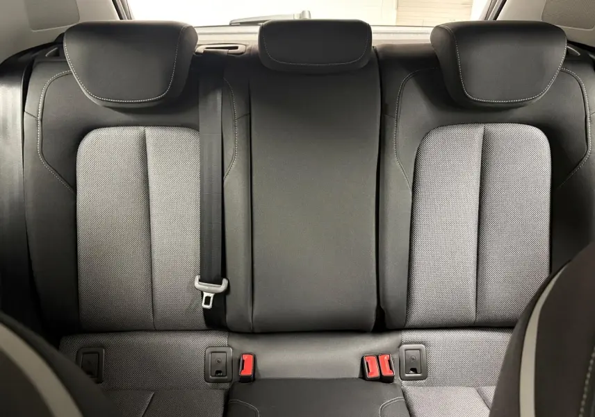 Vue arrière des sièges arrière en tissu noir et gris de l'Audi Q2 35 TFSI S Line 2026, avec ceinture de sécurité centrale visible.