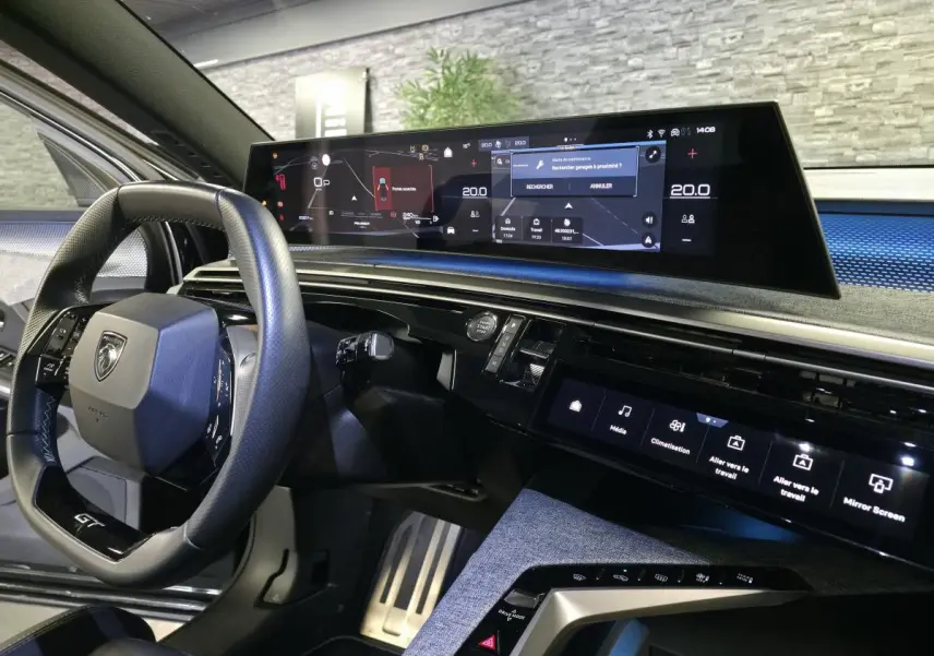 Intérieur du Peugeot 3008 2025 noir, vue du poste de conduite avec écran panoramique incurvé et volant compact GT.