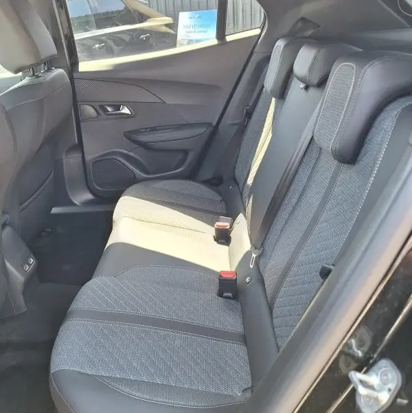 Vue intérieure côté gauche des sièges arrière en tissu gris et cuir noir du Peugeot 2008 Hybrid 136 e-DCS6 Allure noir 2025.