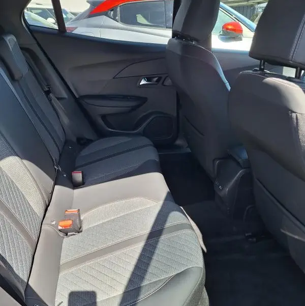 Vue intérieure côté droit des sièges arrière du Peugeot 2008 Hybrid 136 Allure noir, avec sellerie tissu et détails contrastés.