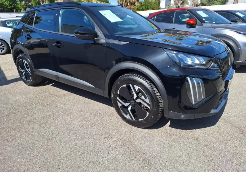 Peugeot 2008 Hybrid noir en 3/4 avant droit, avec barres de toit et jantes alliage 17 pouces visibles.