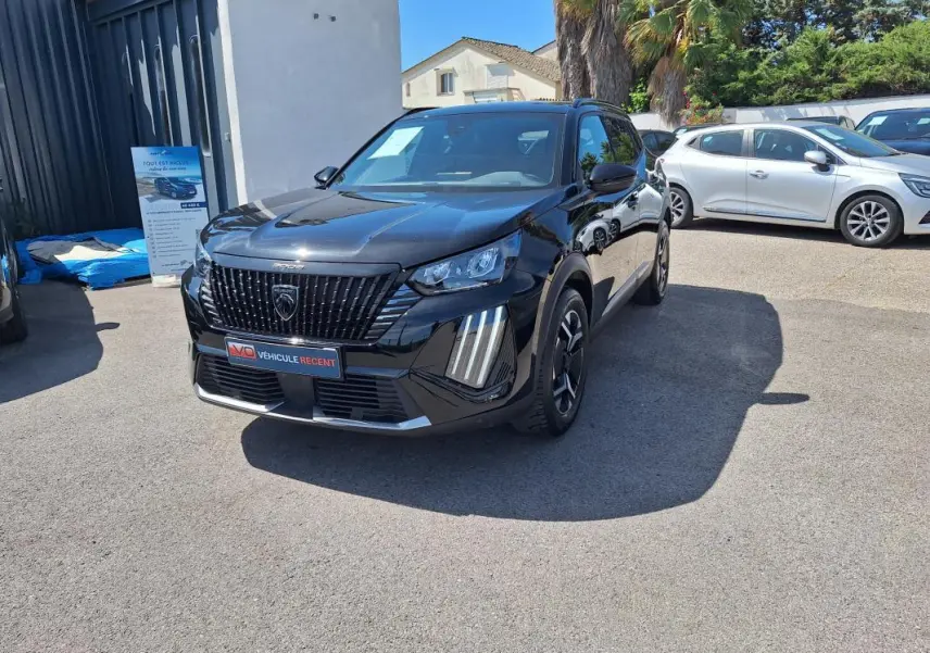 Peugeot 2008 Hybrid noir en 3/4 avant droit, avec barres de toit et jantes alliage 17 pouces visibles.