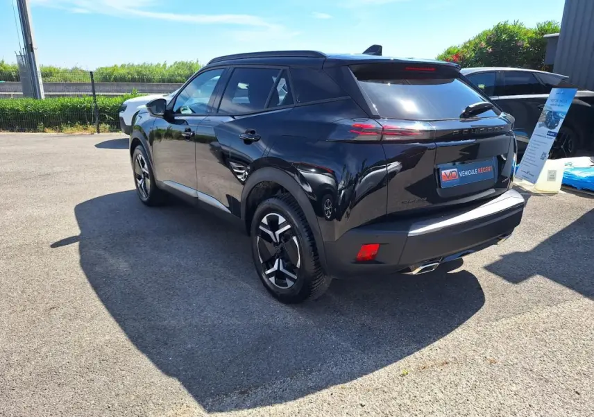 Peugeot 2008 Hybrid noir vue 3/4 arrière droit avec jantes alliage 17 pouces et barres de toit visibles.