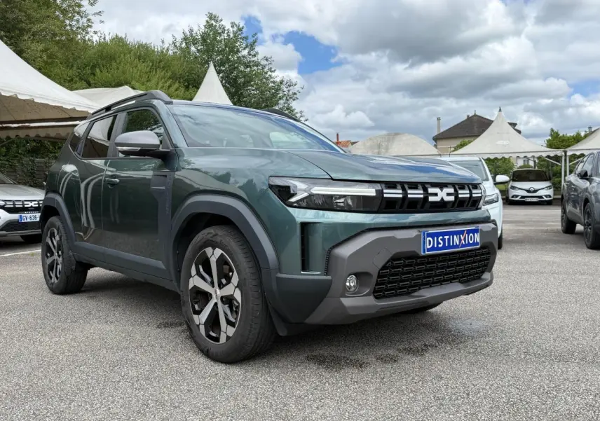 Vue 3/4 avant gauche d’un Dacia Duster Hybrid 140 Journey vert cèdre avec calandre noire et jantes bicolores.