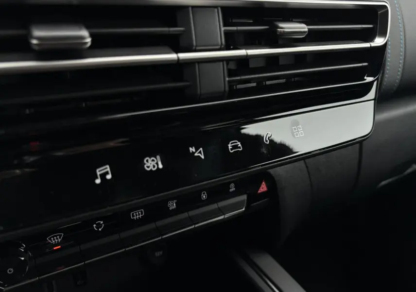 Détail de la console centrale noire brillante du Citroën C5 Aircross 2025 avec commandes tactiles et aérateurs horizontaux.