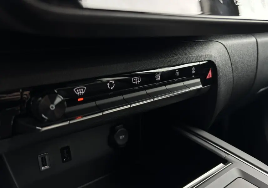 Détail de la console centrale noire du Citroën C5 Aircross 2025, avec commandes climatisation et prises USB visibles.