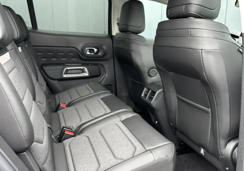 Vue intérieure côté droit des sièges arrière gris et noirs du Citroën C5 Aircross 2025 avec aérateurs centraux visibles.