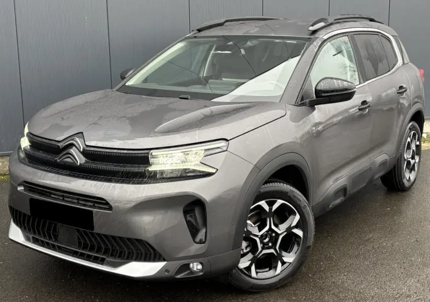 Citroën C5 Aircross gris Platinium en 3/4 avant droit, avec jantes alliage bi-ton et barres de toit noires.