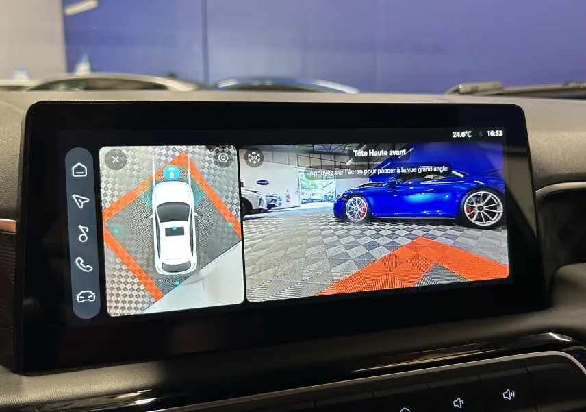 Écran multimédia affichant la caméra 360° et vue avant d’une voiture bleue dans un garage, prise depuis l’habitacle.