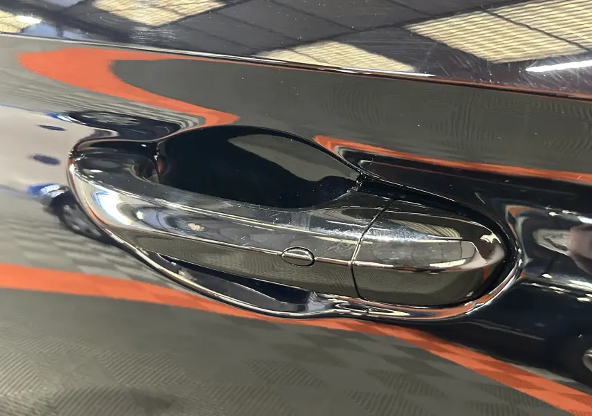 Poignée de porte côté gauche en gros plan sur MG3 Hybrid+ 195 Luxury Pebble Black avec finition brillante.