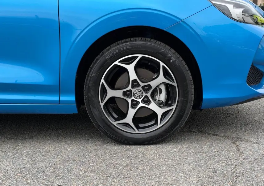 Gros plan sur la roue avant gauche et la jante alu au design sportif du MG3 1.5 Hybrid+ 195ch Luxury en Como Blue métallisé.