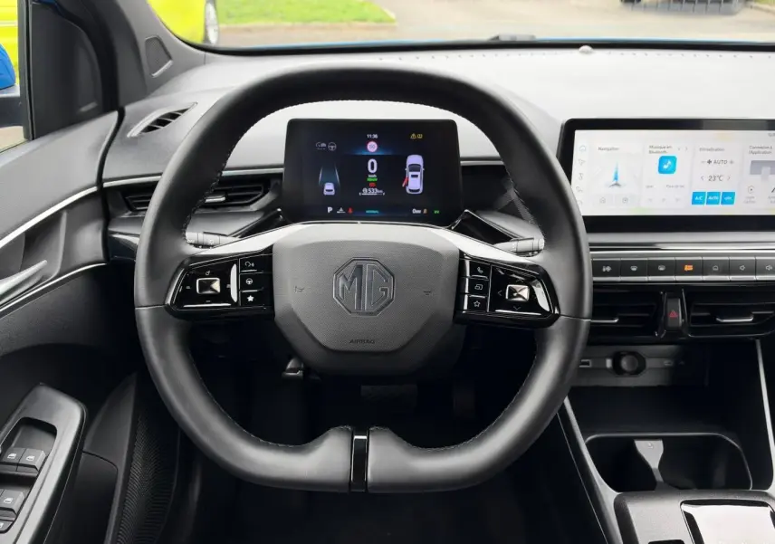 Vue intérieure centrée sur le volant cuir multifonction noir du MG3 1.5 Hybrid+ 195ch avec écran digital et tableau de bord moderne.