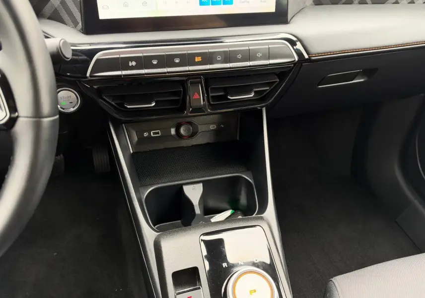 Vue intérieure centrée sur la console centrale et levier rotatif de boîte auto du MG3 1.5 Hybrid+ Luxury, finition noire.