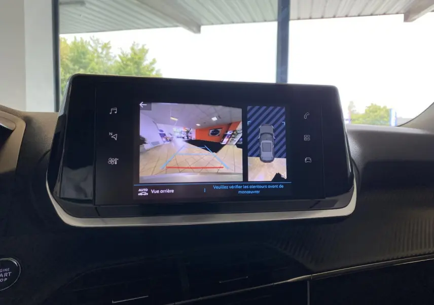 Écran tactile intérieur du Peugeot 2008 e-136 Allure Pack montrant la caméra de recul et l'aide au stationnement.