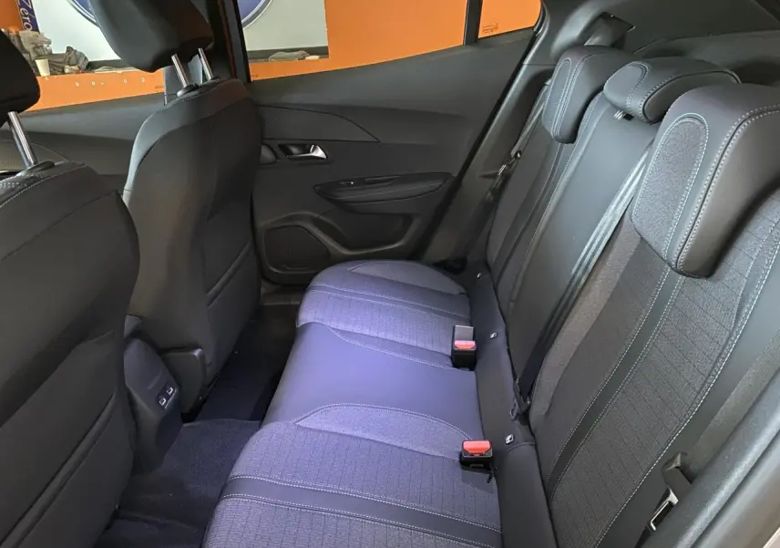 Vue intérieure arrière du Peugeot 2008 e-136 Allure Pack 2022, sièges gris noir en tissu et cuir avec surpiqûres bleues.