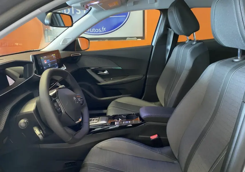 Intérieur avant du Peugeot 2008 e-136 Allure Pack 2022, sièges gris noir et tableau de bord avec écran tactile.