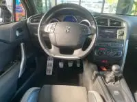 Vue intérieure du poste de conduite de la DS4 gris Platinium 2017, volant DS, tableau de bord et console centrale visibles.