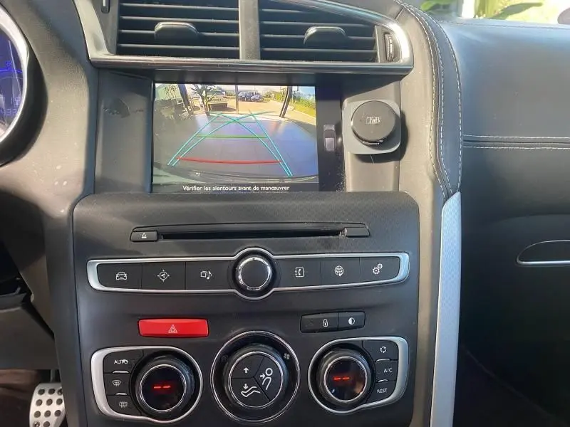 Vue rapprochée du tableau de bord gris du DS4 2017 montrant l'écran de caméra de recul avec guidage coloré.