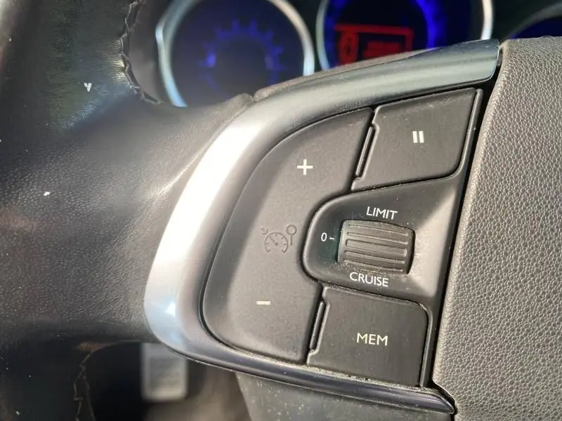 Gros plan sur les commandes de régulateur de vitesse au volant d'une DS4 gris Platinium de 2017.