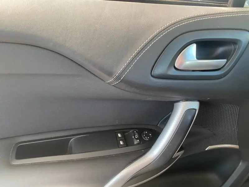 Détail de la porte côté gauche de la DS4 2017 gris Platinium, avec poignée argentée et commandes électriques des vitres.