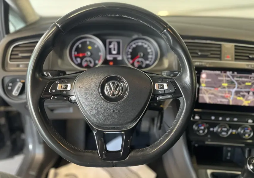 Volant en cuir noir de Volkswagen Golf SW 2017 avec tableau de bord et écran tactile de navigation visible.