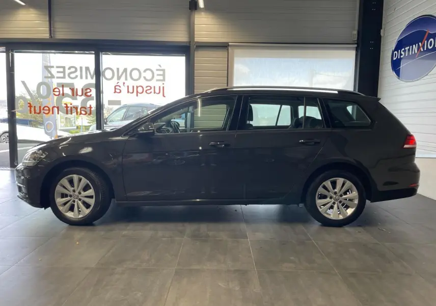 Profil côté gauche d'une Volkswagen Golf SW gris foncé 2017 en intérieur, avec jantes alliage 16 pouces visibles.