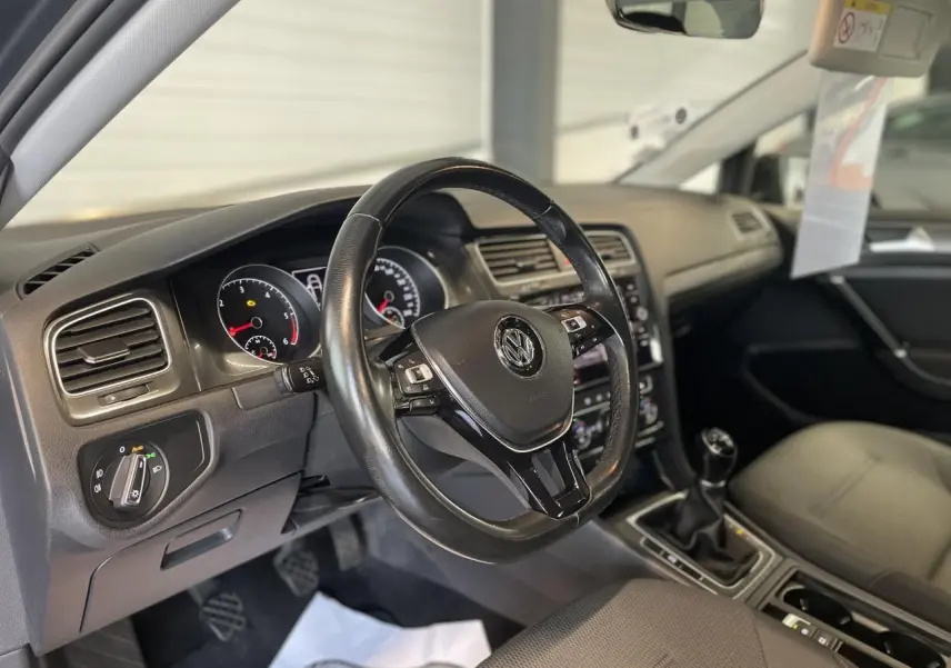 Intérieur de Volkswagen Golf SW 2017, vue côté conducteur sur volant cuir multifonction et levier de vitesses manuel.