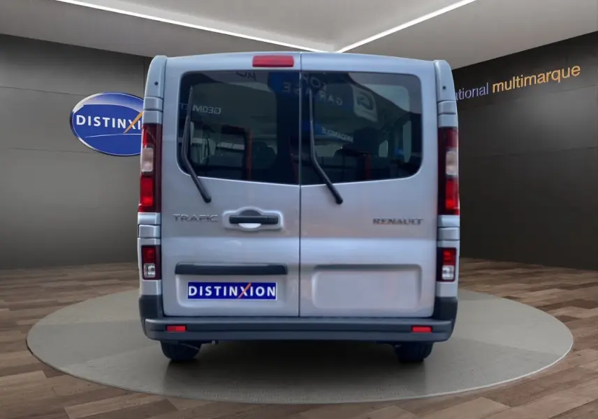 Vue arrière du Renault Trafic Combi gris platine 2023, avec portes battantes et essuie-glaces arrière visibles.