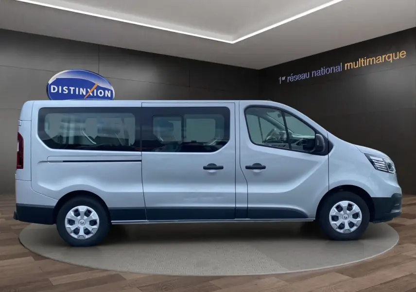 Vue de profil côté gauche d’un Renault Trafic Combi gris platine 2023, version 9 places avec vitres latérales teintées.