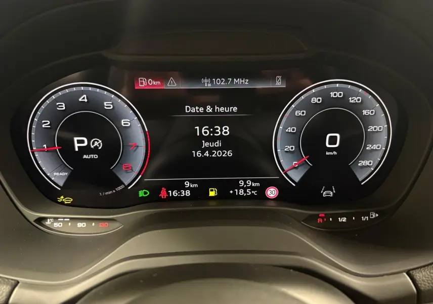 Vue rapprochée du tableau de bord numérique de l'Audi Q2 35 TFSI 2026 affichant la date, l'heure et les compteurs en mode parking.