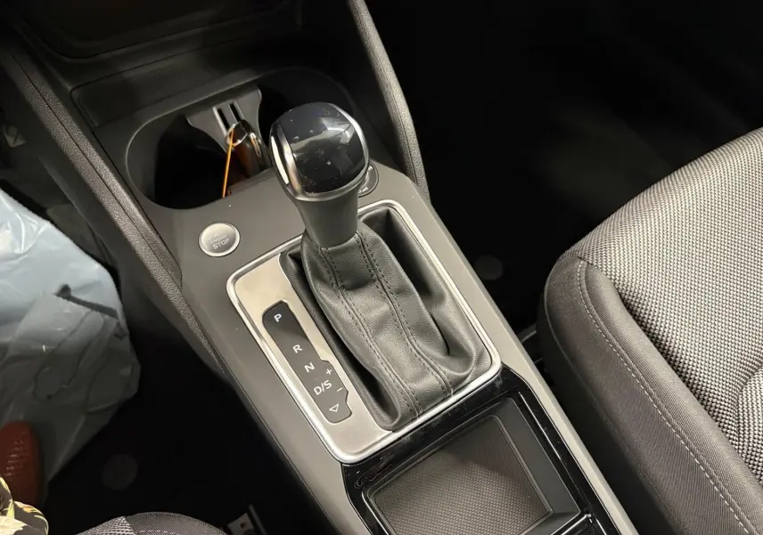 Gros plan sur la console centrale avec levier de vitesse automatique et bouton start/stop dans un Audi Q2 35 TFSI noir mythic.