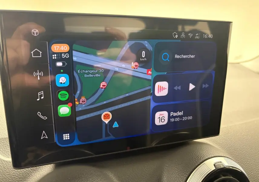 Écran tactile central de l'Audi Q2 35 TFSI S Line 2026 affichant navigation et applications, intérieur noir.
