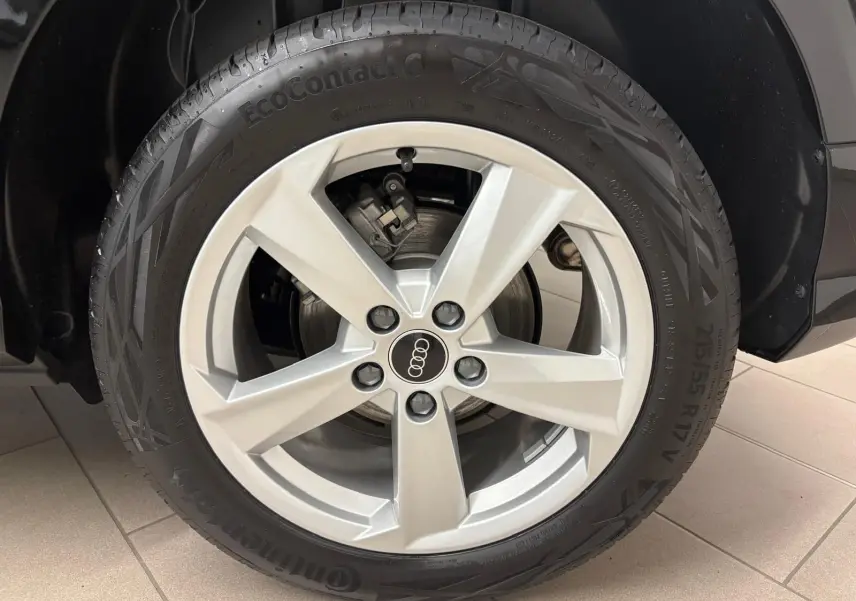 Gros plan sur la roue avant droite de l'Audi Q2 35 TFSI S Line 2026 en Noir Mythic avec jante argentée cinq branches.