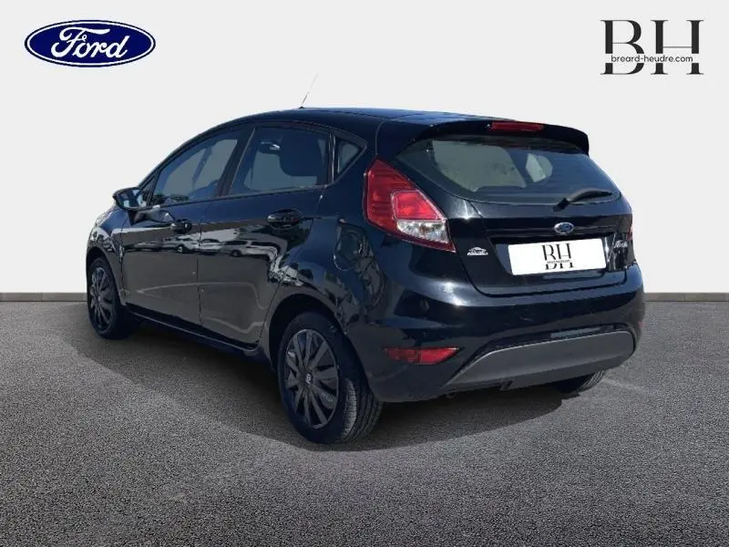 Vue 3/4 arrière droite d'une Ford Fiesta noire 5 portes, version diesel 1.5 TDCi, avec feux arrière distinctifs.