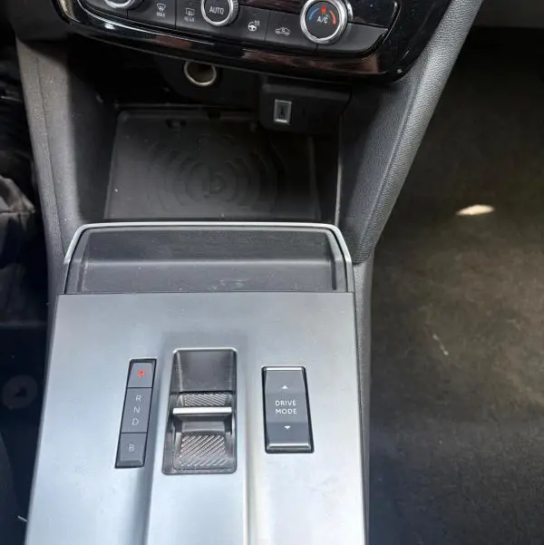 Vue rapprochée de la console centrale grise de l’Opel Mokka électrique 2025 avec commandes de boîte auto et climatisation.