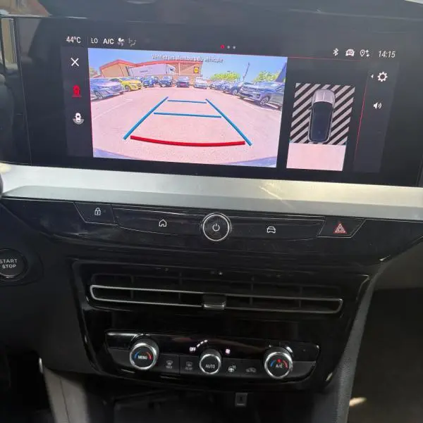 Vue intérieure de l'Opel Mokka électrique 2025, écran tactile affichant la caméra de recul et commandes climatisation.